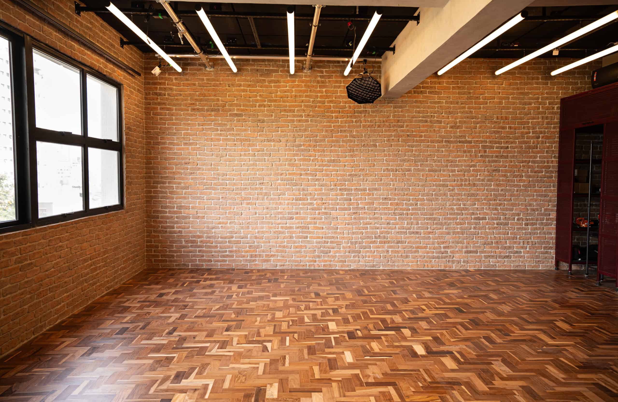 Loft com tijolo, madeira e luz natural.